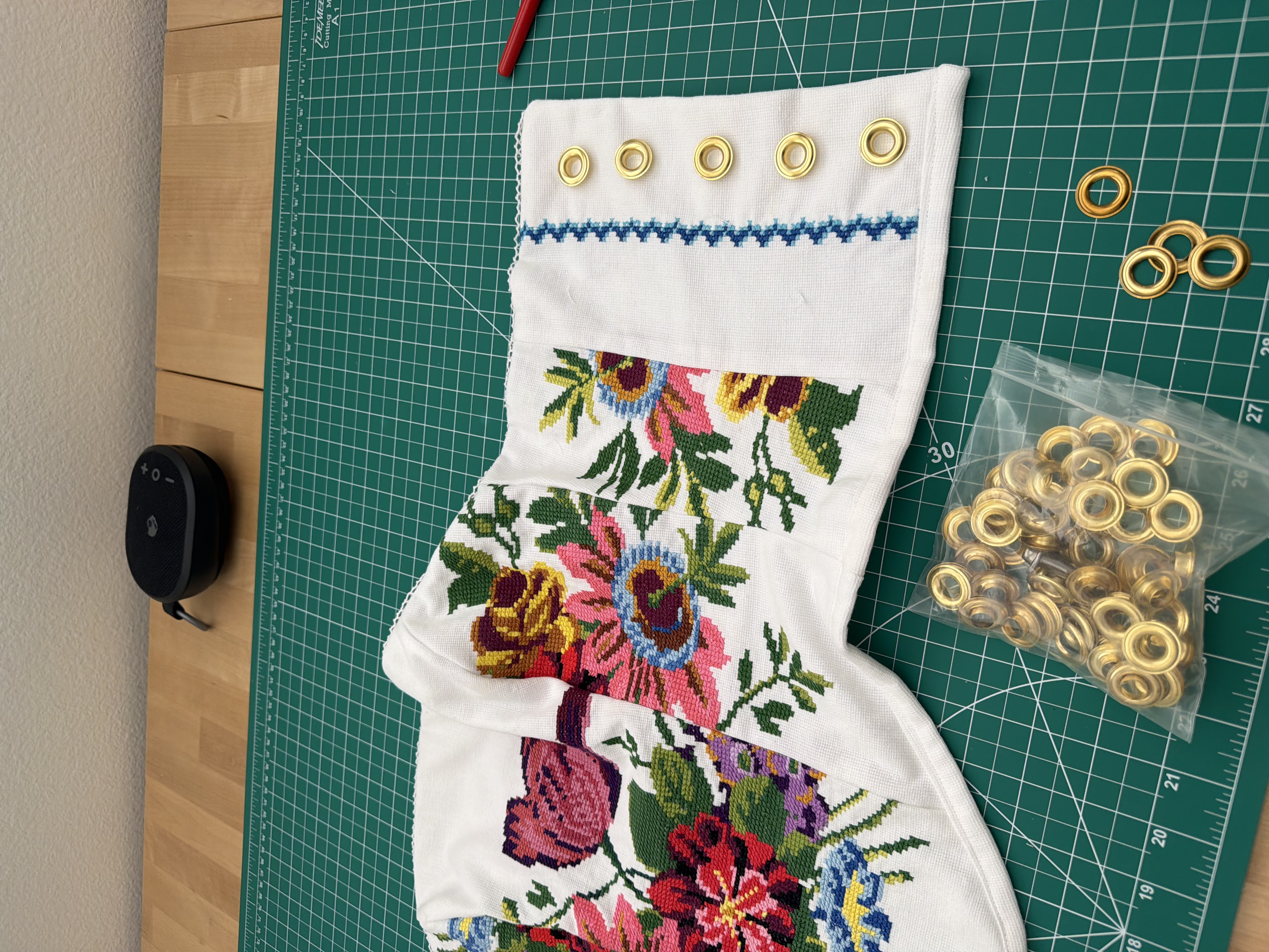 The gold grommets used instead, next to the blue zigzag needlepoint trim and the bag they came in